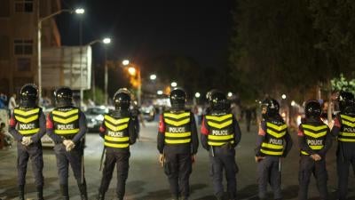  Jordanian police block a road in front of protestors in Irbid, north of Jordan on August 1, 2020.