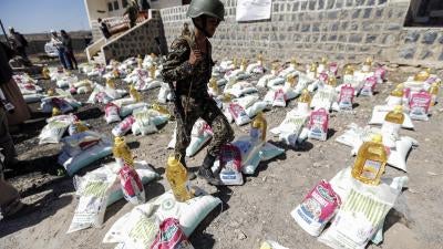 A uniformed soldier walks through aid packages