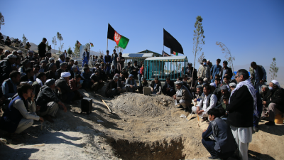Afghan men bury a victim of the suicide attack that targeted a school  in Kabul, Afghanistan, October 25, 2020