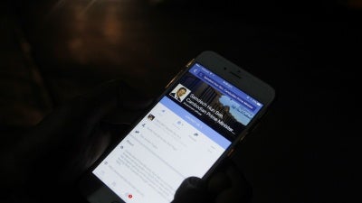 A man views Cambodian Prime Minister Hun Sen's Facebook page on his mobile phone in downtown Phnom Penh, Cambodia.
