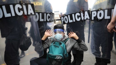 Police surround a protester in Lima, Peru, Tuesday, Nov. 10, 2020.