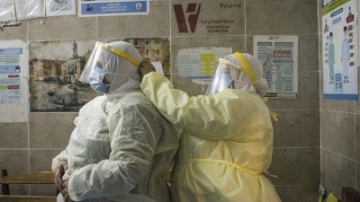 A nurse helps a colleague put on personal protective equipment at the 6th of October Central Hospital, an isolation hospital for Covid-19 patients, in Giza, Egypt, in July 2020.