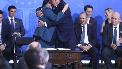 Brazilian President Jair Bolsonaro embraces the Minister of Women, Family, and Human Rights, Damares Alves, during a ceremony on August 29, 2019, in Brasilia, Brazil. ©Agência Brasil / Valter Campanato