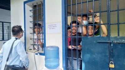 Arrested teachers and adult Indigenous students confer with their lawyer while detained in a Cebu City jail. 