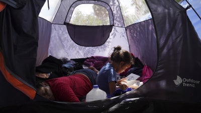 Asylum seeker Yareni, age five, flips through the pages of a book in an encampment where she lives near the Gateway International Bridge in Matamoros, Mexico. 