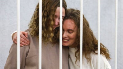 Journalists Ekaterina Andreyeva (Bakhvalova), right, and Daria Chultsova embrace inside the defendants' cage during a court hearing in Minsk, Belarus, February 9, 2021. 