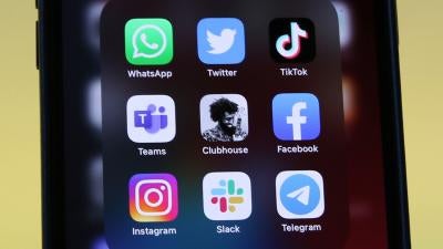 Logos of social media platforms including Clubhouse, center, are seen on an iPhone 12.