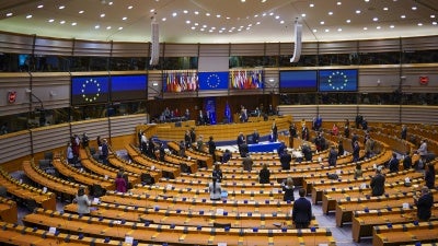 European lawmakers stand up during a signing ceremony at the European Parliament, Brussels, Belgium, March 10, 2021. 