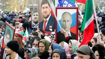 People hold portraits of Russian President Vladimir Putin and Chechen leader Ramzan Kadyrov during a rally marking National Unity Day in Grozny, southern Russia, Monday, Nov. 4, 2019.