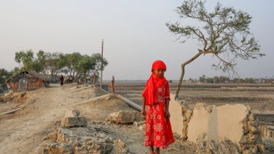 A girl surrounded by land devastated by Cyclone Amphan in Satkhira