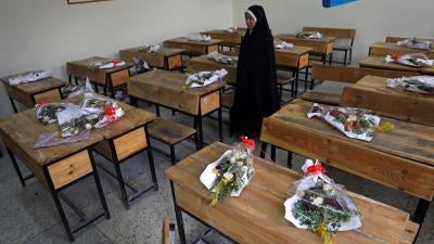 The mother of a schoolgirl who was among those killed in the brutal May 8, 2021 bombing of the Sayed ul-Shuhada girls' school stands inside a classroom with bouquets of flowers on empty desks as a tribute to the dead, in Kabul, Afghanistan, May 16, 2021. 