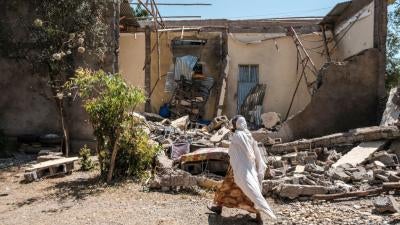 A woman walks past a house that was damaged by shelling when federal-aligned forces entered the town of Wukro, in Ethiopia's Tigray region, March 1, 2021. 