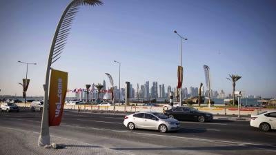 Evening traffic on the Corniche promenade with the skyline of West Bay Doha the background 