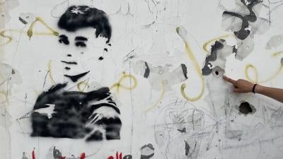  رسم لمحمد السليم على جدار مدرسة ركض بجوارها أثناء فراره من جنود إسرائيليين أطلقوا النار عليه في ظهره، 5 مايو/أيار 2023. قال شهود إن إطلاق نار من أسلحة آلية خلّف آثار 10 رصاصات في الجدار، قرب عزون، في الضفة الغربية.