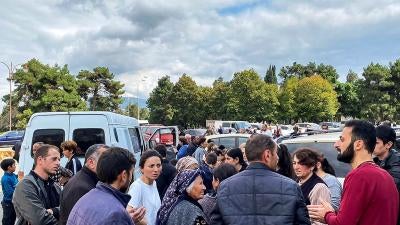 A local government worker, right in red, tries to reassure residents during shooting in the vicinity, in Stepanakert/Khankendi, Nagorno-Karabakh on September 21, 2023. 