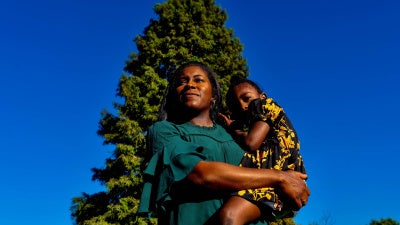 A woman poses for a photo holding her son