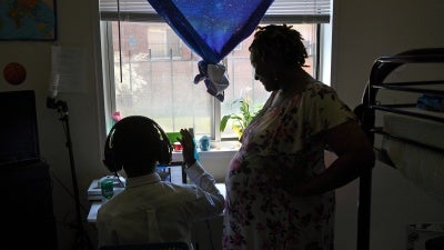 A pregnant woman checks in on her son in their apartment in Washington, DC. during the Covid-19 pandemic,  July 14, 2020.