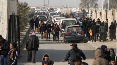 Displaced people who fled the Aleppo countryside walk in Tabqa, Syria, December 4, 2024. 