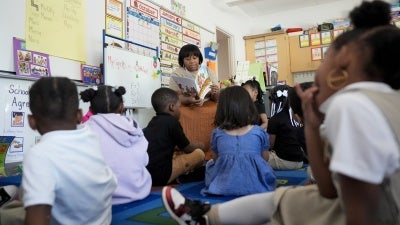 A preschool teacher reads to students at Dorothy I. Height Elementary School in Baltimore, Maryland, US, October 3, 2024.