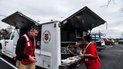 Director of Divisional Emergency Response of the Salvation Army William Trueblood (L) distributes food outside the Cayce United Methodist Church in Cayce, Kentucky, US, December 15, 2021, five days after tornadoes hit the area. 
