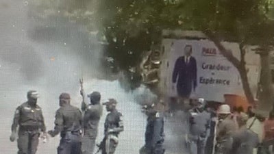 Police surrounded by clouds of tear gas