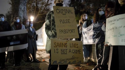 Protesters hold placards in solidarity with humanitarians who were still detained in Greece, November 18, 2021.