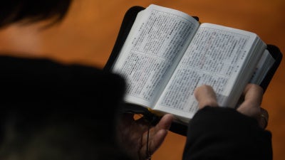 A church member reads a bible during a service in Hong Kong in solidarity with the Early Rain Covenant Church in China, whose members face persecution, December 18, 2023. 
