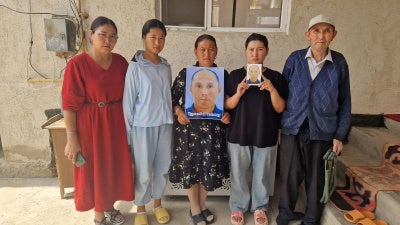 Family members and neighbor (far right) of Alimnur Turganbay, a Kazakhstan citizen detained in China, outside their house in Uzynagash village, located outside Almaty, Kazakhstan on August 4, 2025.