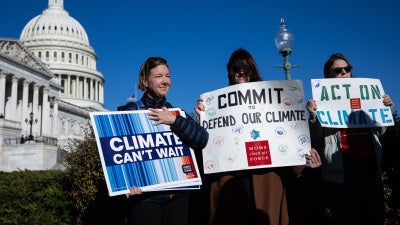 Climate activists hold signs during a press conference outside the US capitol building