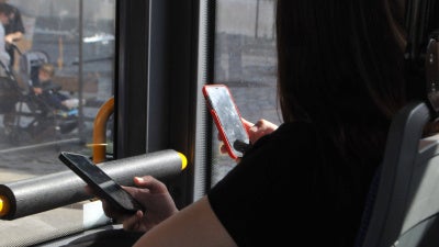 People using their cellphones while in transit, September 2023.