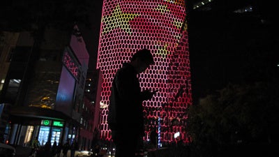 A person standing before an image of the Chinese national flag in Beijing, October 23, 2017. 