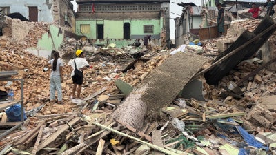 Following the March 28, 2025 earthquake in Myanmar, people clear debris from damaged buildings in Naypyidaw, April 7, 2025.
