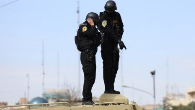 Iranian security forces stand guard on top of an armored vehicle in Tehran on March 21, 2026.