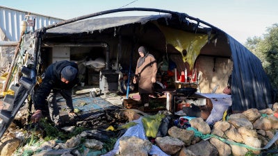 Residents inspect damaged belongings inside a tent burned by suspected Israeli settlers in the village of Susya in Masafer Yatta, south of Hebron, in the Israeli-occupied West Bank, February 25, 2026. 
