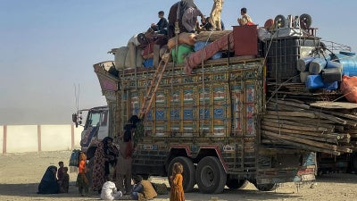 Afghan refugees board a truck with their belongings as they await deportation at the Pakistan-Afghanistan border in Chaman on October 19, 2025.
