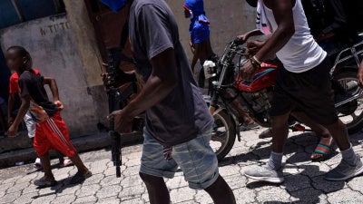 Children accompany criminal group members in a march in the Delmas neighborhood of Port-au-Prince, Haiti, May 10, 2024.