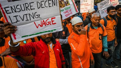 Delivery workers of an Indian food-delivery startup hold placards during a demonstration demanding a hike in their remuneration, in Kolkata, on November 22, 2022.