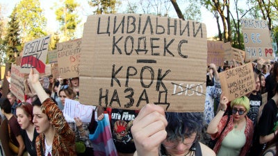A placard reads "Civil Code Is Step Back" during a peaceful protest to urge MPs to refine the draft of the new Civil Code taking into account amendments proposed by human rights activists, in Mariinsky Park, Kyiv, Ukraine, May 5, 2026.