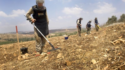 A team from the Mines Advisory Group (MAG) clearing unexploded cluster munitions on farmland in southern Lebanon, November 10, 2020. 