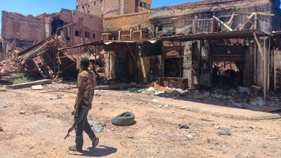 A fighter loyal to the army patrols a market area in Khartoum on March 24, 2025.