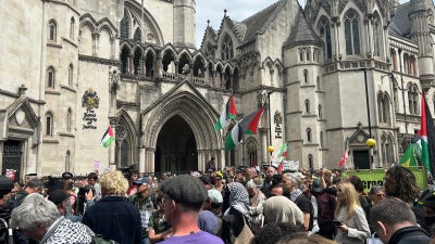 Protesters gather outside the Royal Courts of Justice on the Strand listening to the judge's statement, London, UK, June 15, 2026.
