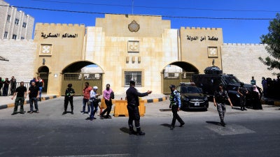 Security members stand guard outside the State Security Court in Amman, Jordan, July 12, 2021.