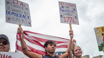 Protesters hold US flags and placards during a nationwide "No Kings" rally