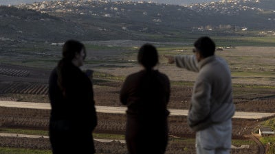 Israelis look at the border with Lebanon from a position in the northern village of Metula on March 5, 2026, after Hezbollah launched rockets at Israel during the ongoing conflict.