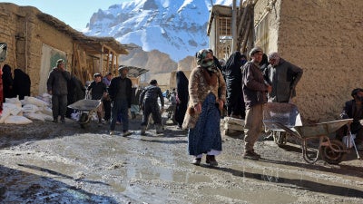 People congregate outside a World Food Programme food distribution center in Yakawlang, Bamyan province, Afghanistan, January 1, 2026. 