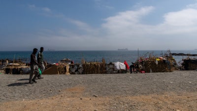 Two of the migrants and asylum seekers who swan to Ceuta in July 2026, walk on the Trampolín beach, August 2026.