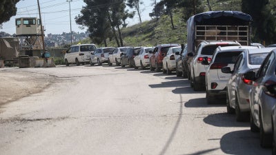 Palestinians wait to cross at the Israeli Awarta military checkpoint on March 23, 2025, south of Nablus in the West Bank.