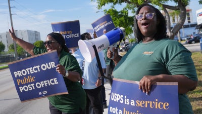 People demonstrate against proposed changes to the US Postal Service and President Donald Trump's executive order regarding mail-in ballots, Miami, Florida, July 28, 2026. 