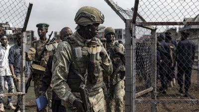 A member of the M23 looks on during an enrollment of civilians, police officers, and former members of the Congolese armed forces who have been recruited in Goma on February 23, 2025. 