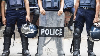 Non-identifiable police officers holding riot shields